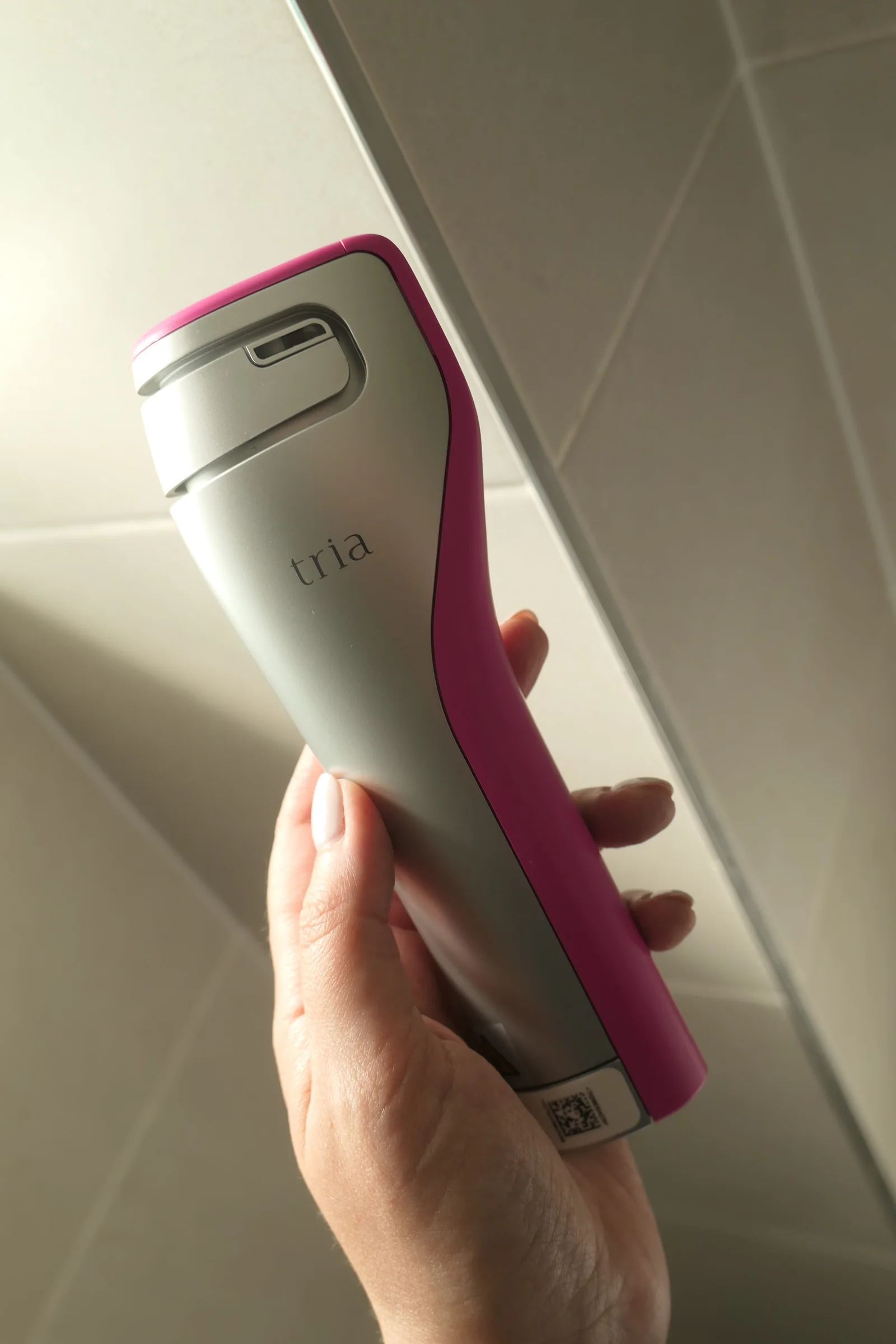 Elena holding a silver and pink Tria FRX skin rejuvenating laser